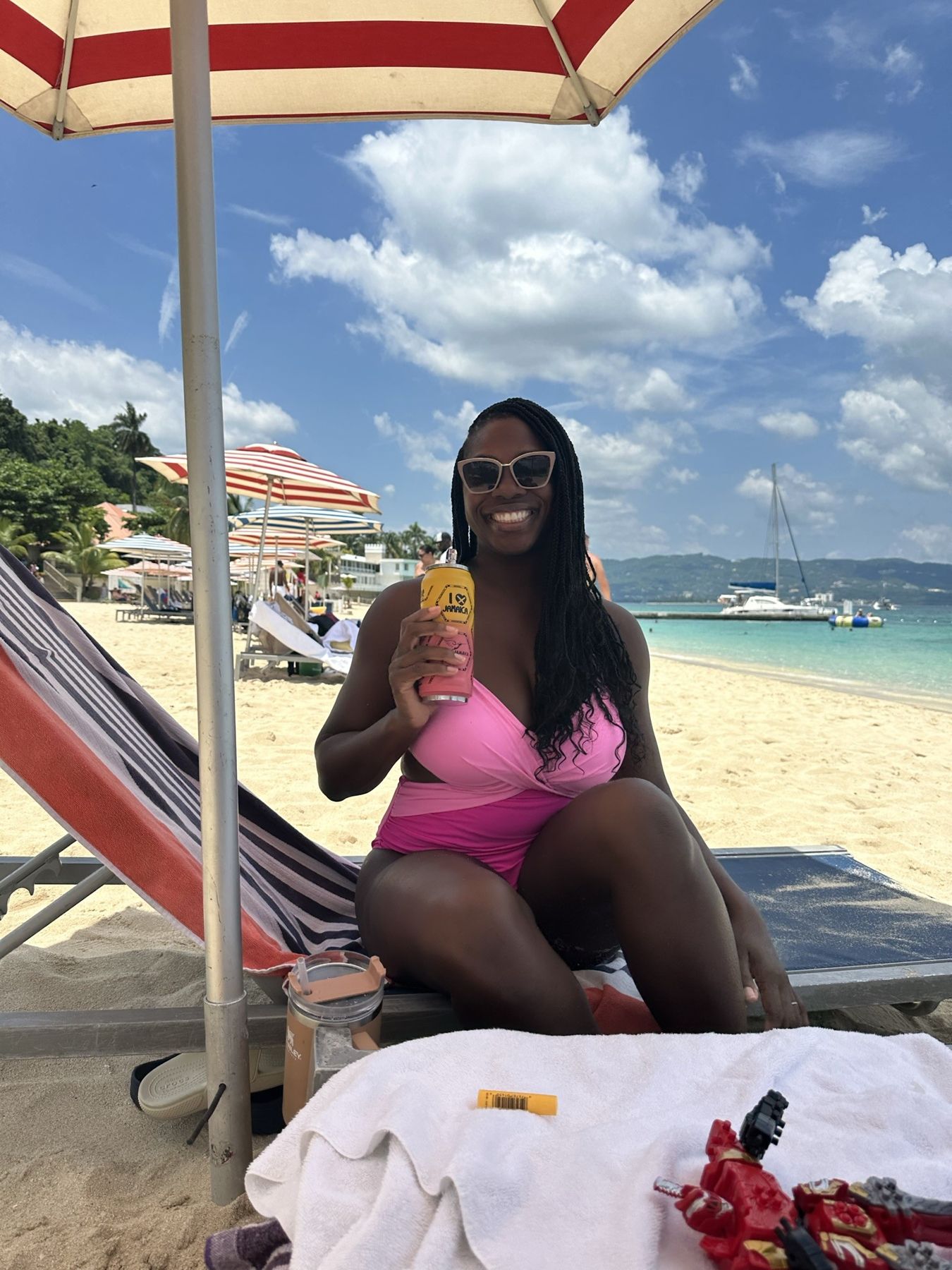 Nikki on a beach lounger at Doctor's Cave Beach, Montego Bay, holding a Jamaican drink