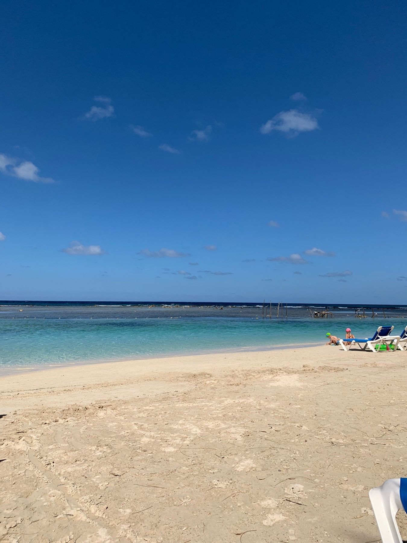 An empty white-sand beach with turquoise water at Runaway Bay, mid-morning