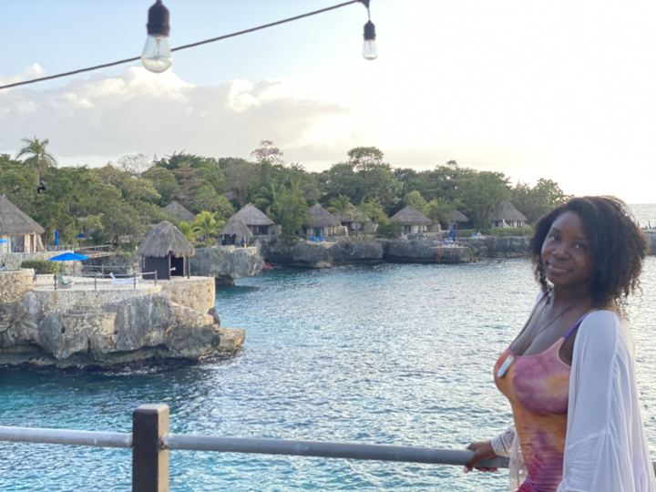 Turquoise cove with thatched cliff villas at Rockhouse, Negril West End, at golden hour